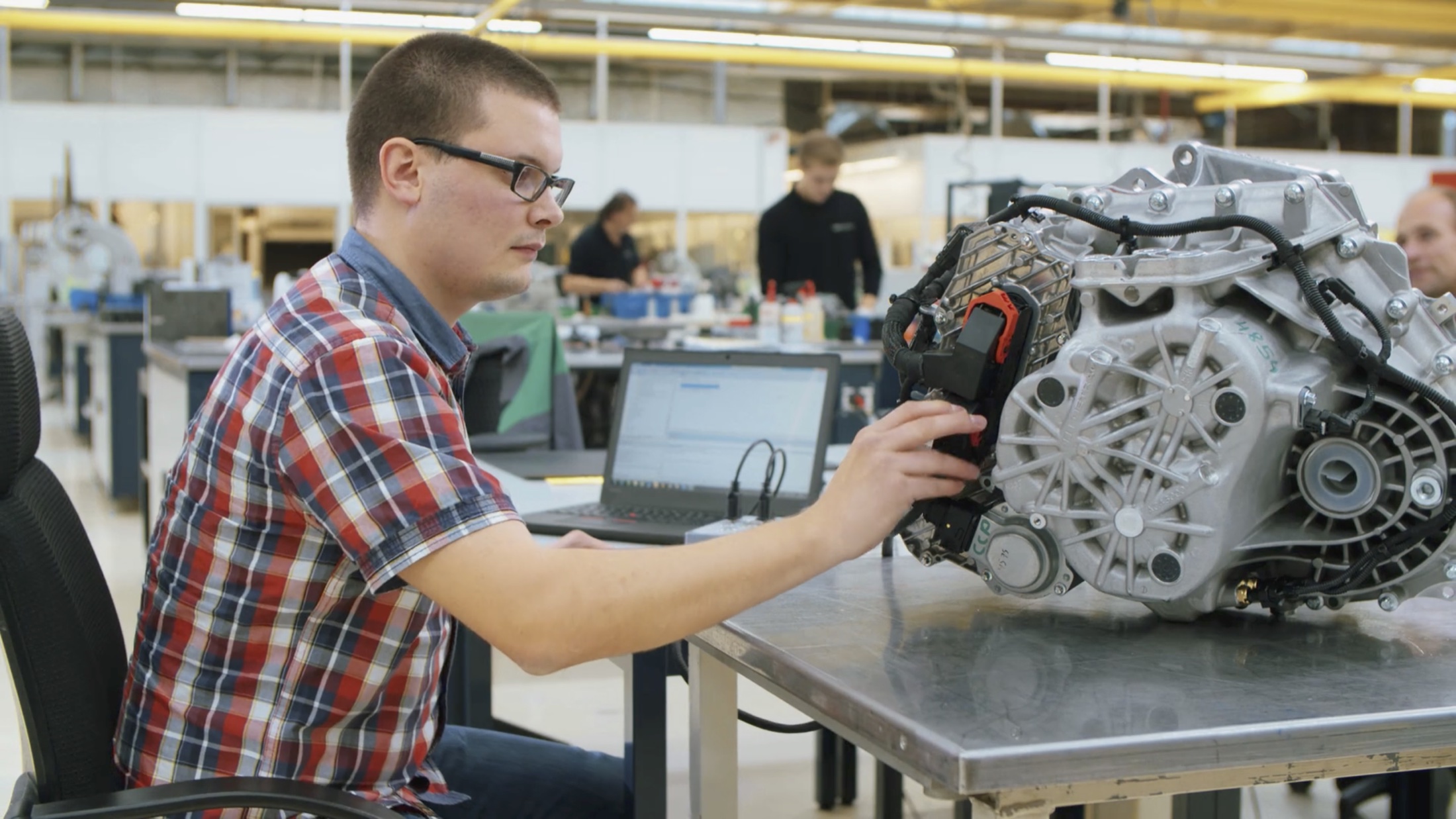 Auszubildender von MAGNA bei der Arbeit an einem Getriebe